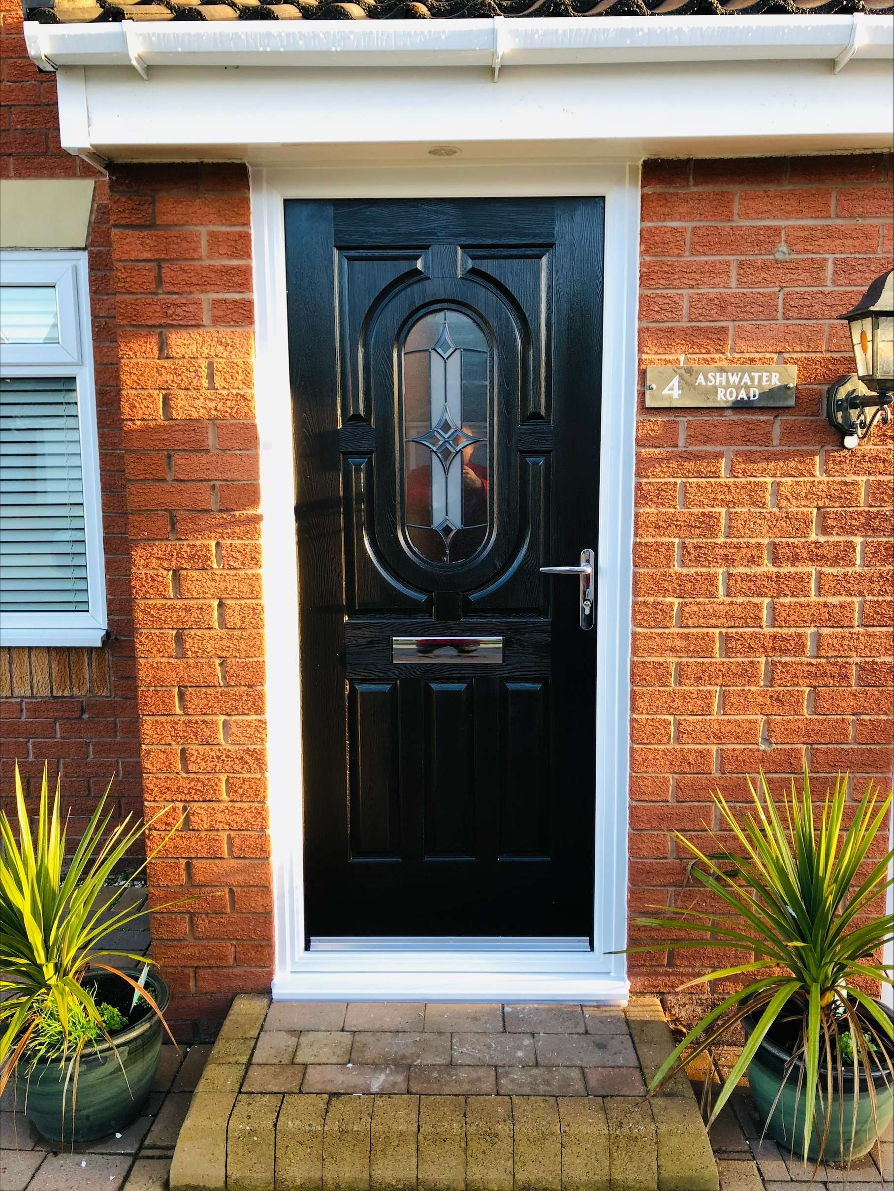 Black composite front door with oval decorative glass panel