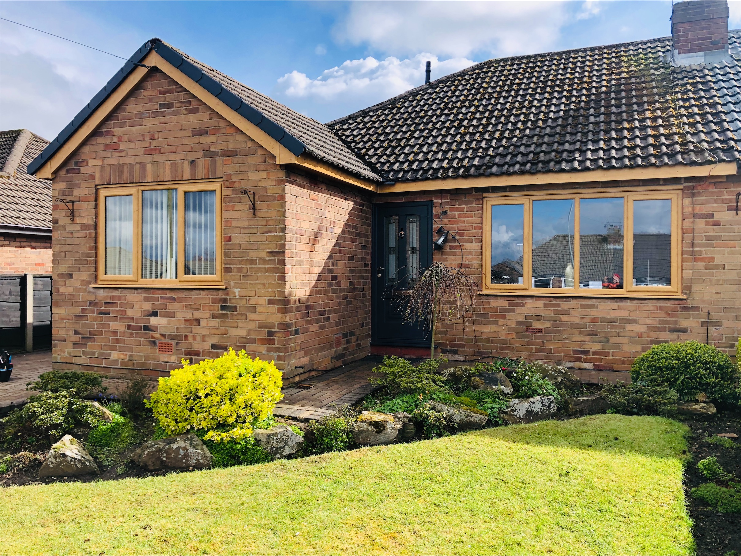 Bungalow with oak effect UPVC windows and grey composite front door