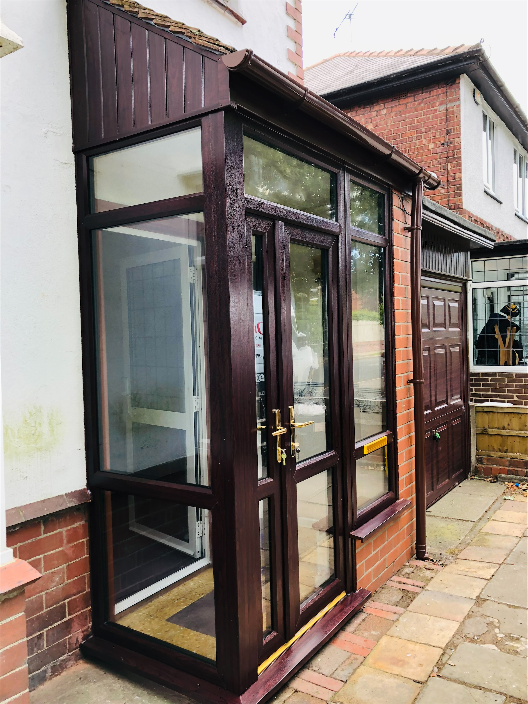 Rosewood effect UPVC porch with french doors and gold handles