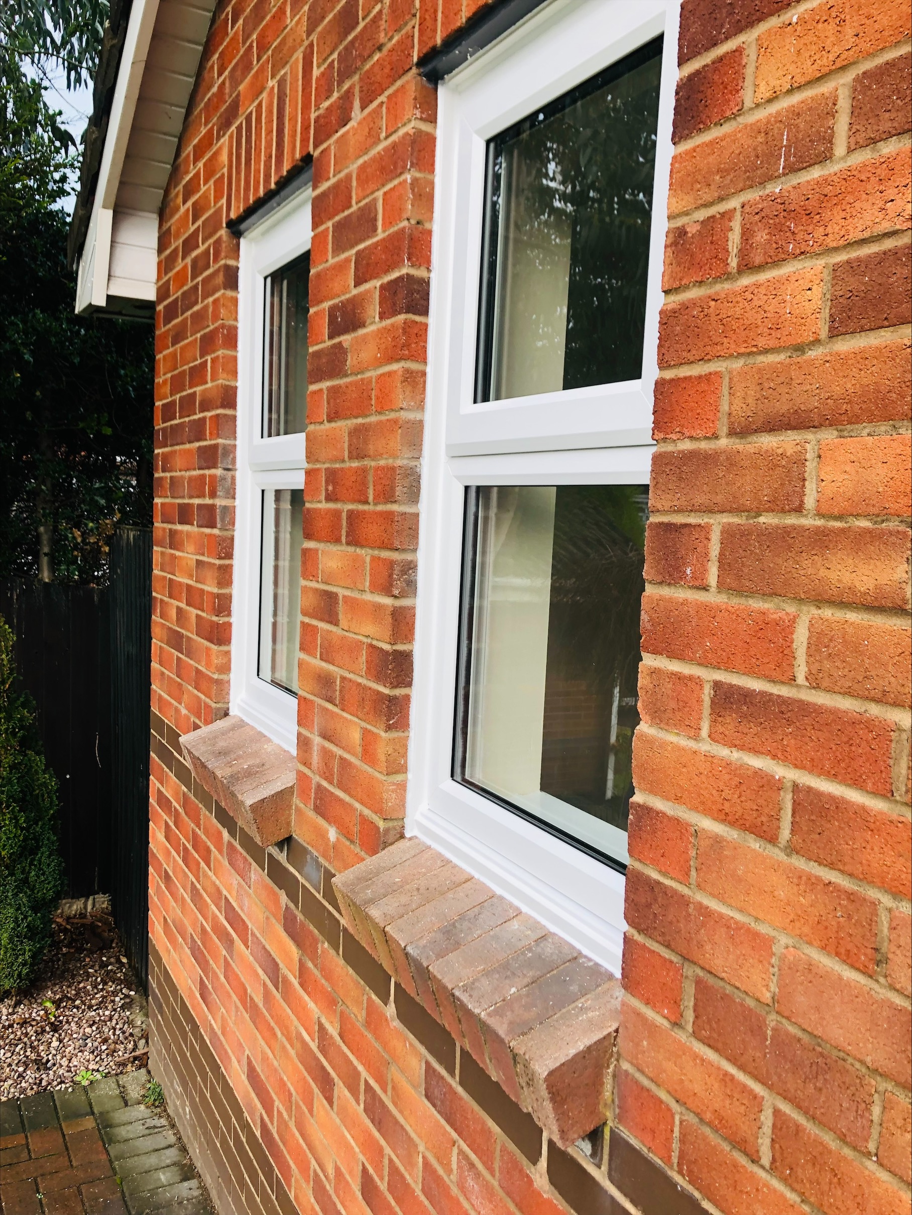 White UPVC windows on red brick house exterior